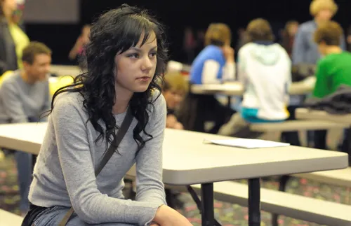 a woman sitting apart from a group of people