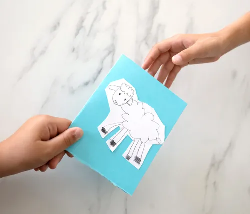 Hands holding a card with a sheep on it