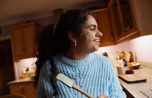 a woman smiling and cooking in a kitchen