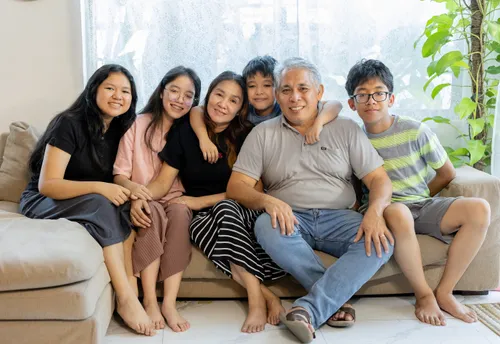 Photo of Adam and his family sitting on the couch