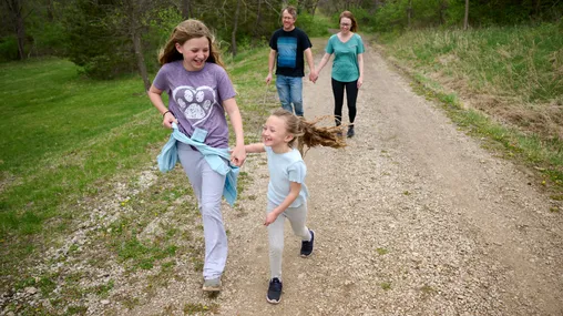 A family walks together around the fields of the Adam-ondi-Ahman Historic site.