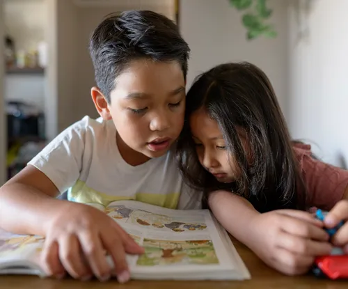 Santiago reading a book with his little sister