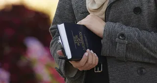 young woman holding Book of Mormon