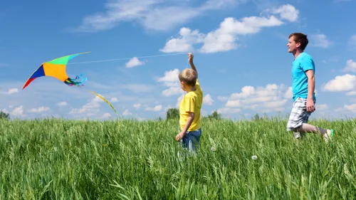 Father and son flying a kite.