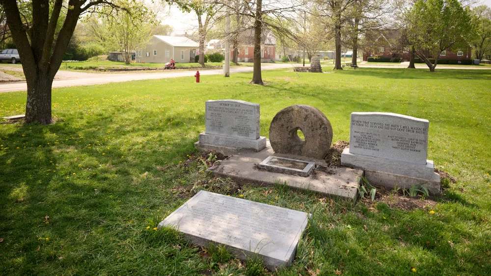 A Hawn's Mill Millstone Monument rests on a grassy field in nearby Breckenridge, Missouri
