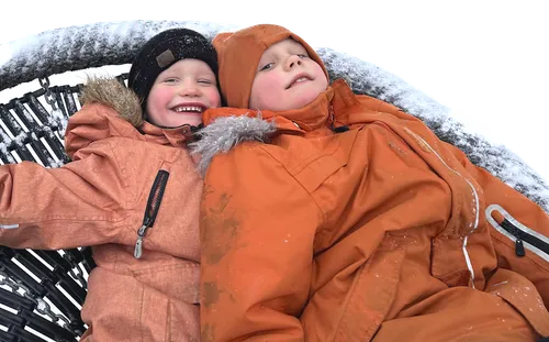 Two smiling boys wearing cold-weather clothes
