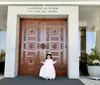 Young girl in a white dress standing in front of temple doors
