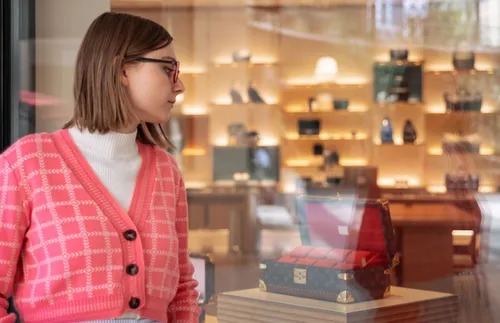young adult woman looking through a shop window