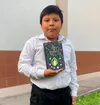 Boy holding a Book of Mormon
