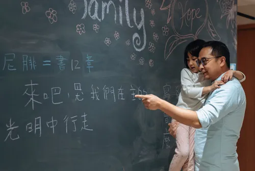 Dad and daughter looking at writing on a chalkboard