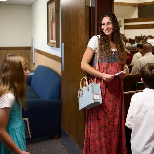 young woman greeting people at church