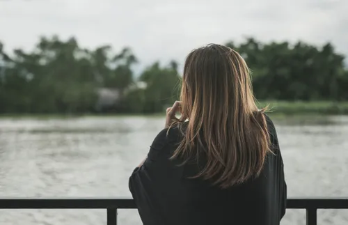 a young woman looking out over a pond