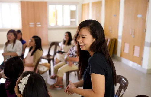 a young woman smiling and standing in Relief Society