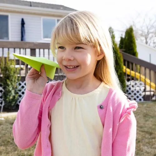 Smiling girl holding a paper airplane