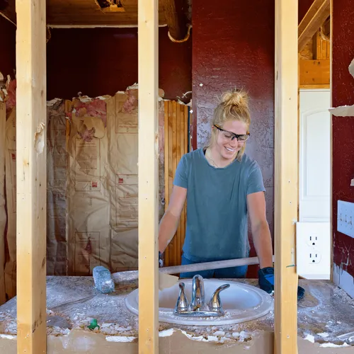 young woman with a sledgehammer at a construction site