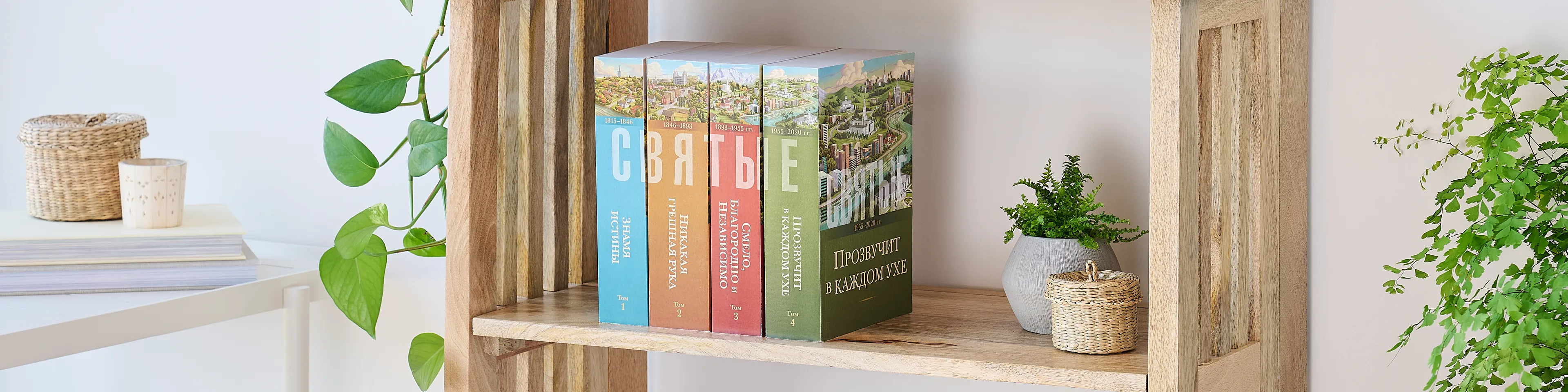 Picture of the book series, 'Saints' volume 1-4 (Russian edition). Four volumes are arranged on the middle shelf of a wooden bookshelf along with plants.