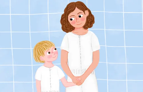 Boy and woman standing in white baptismal jumpers