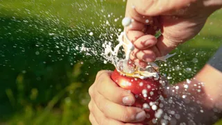Thirsty man opens a can of shaken up beer during picnic 