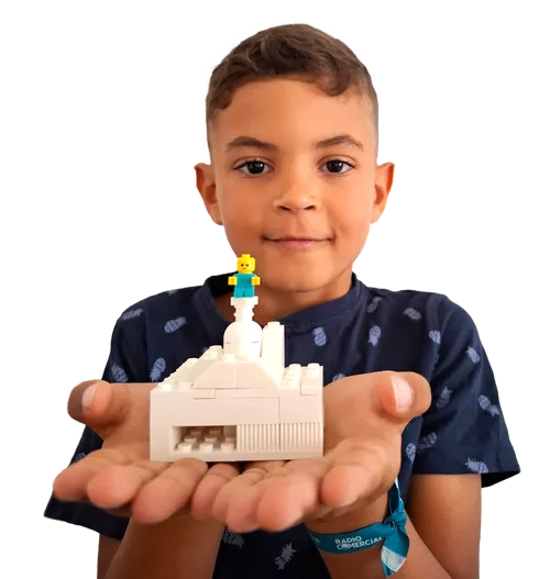 Boy holding a temple he built out of toy bricks