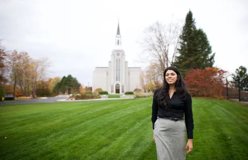 a smiling woman walking in front of the temple