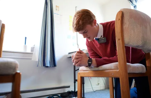 a young missionary kneeling and praying