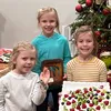 Three children holding a pavlova