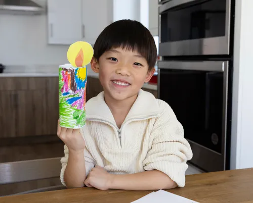 Child holding a paper candle craft