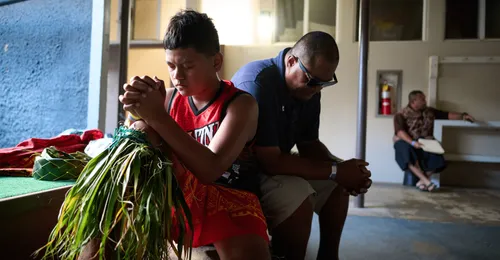young man praying with family member