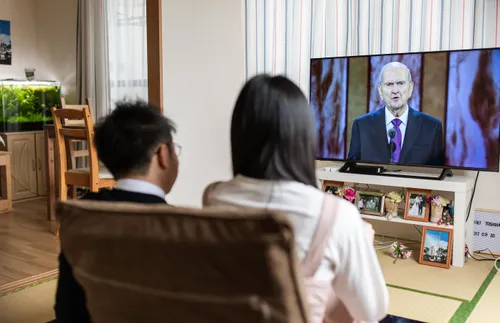 a young couple watching general conference