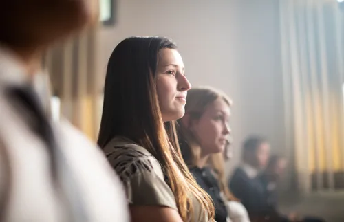 a young adult woman sitting in sacrament meeting