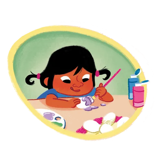 Little girl sticks her tongue out while she paints an egg