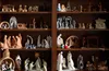 various sets of Nativity scenes on shelves