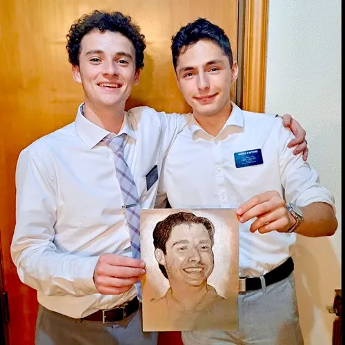 Elder Beck and Elder d’Antuono holding a portrait of Elder d’Antuono’s father