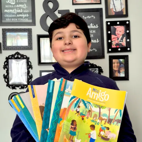 Photo of boy with copies of the Friend magazine