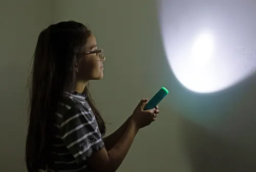 Girl shining flashlight on the wall