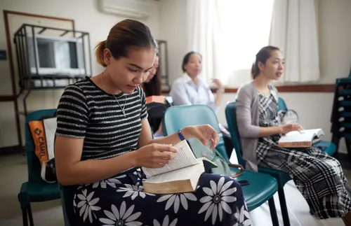 women sitting in Relief Society and studying the scriptures