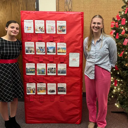 young women standing by homemade Giving Machine