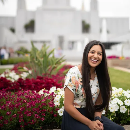 a woman smiling and laughing in front of the temple
