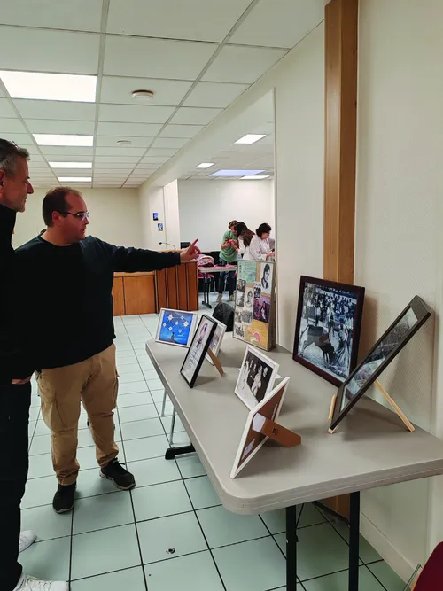 Brother Amorin showing photos of his family bullfighting at an ancestry exhibition.