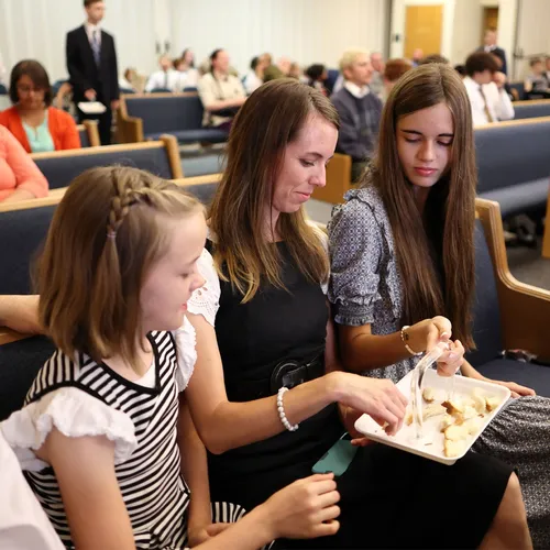 people partaking of the bread during sacrament meeting