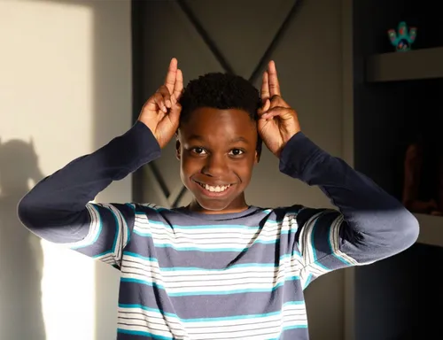 Child holding up their fingers to make rabbit ears